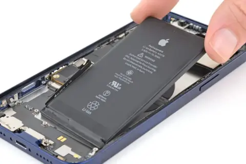 Wyjmowanie baterii z iPhone'a 13.