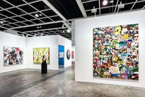 A vibrant collage artwork dominates the wall at Art Basel, showcasing a diverse collection of images.