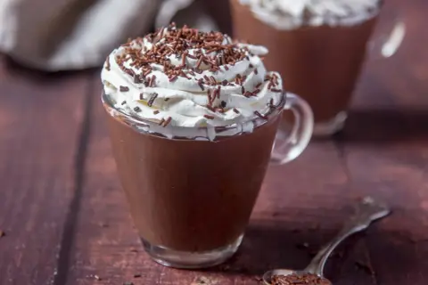Cioccolata calda con acqua e cacao, guarnita con panna montata e codette di cioccolato. Un comfort food perfetto per riscaldarsi.