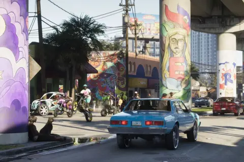 Kolorowe murale zdobią filary wiaduktu. Na ulicy ruch, motocykle i samochody, jakbyśmy czekali na GTA 6.