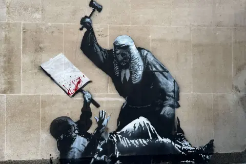 A judge wielding a gavel over a fallen figure, a signature piece by Banksy, questioning justice.