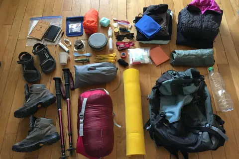 Préparation du contenu sac rando 3 jours : chaussures, sac de couchage, matelas, vêtements, gourde, kit de premiers secours, et autres essentiels.