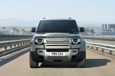 Nowy Range Rover Defender jedzie autostradą, gotowy na każdą przygodę.