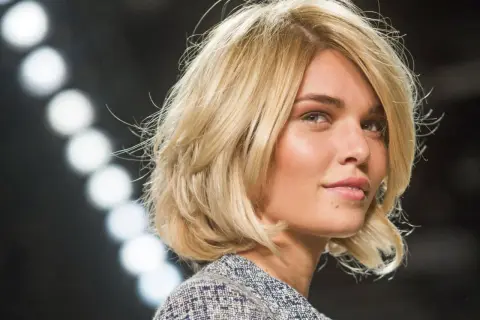 Blondes Modell mit einem lässigen, **choppy bob** und einem Tweed-Jackett.
