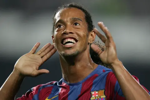 Uśmiechnięty Ronaldinho w koszulce Barcelony, z dłońmi przy uszach, jakby słuchał dopingu. Tak, Ronaldinho żyje i wciąż zachwyca!