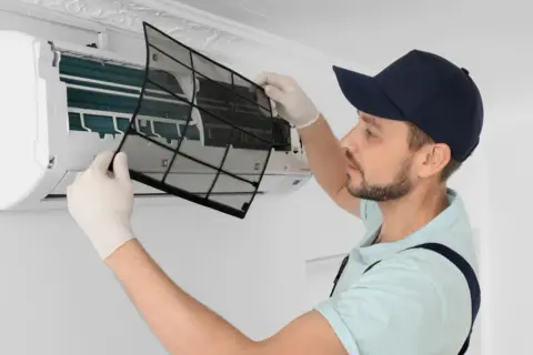 Tecnico rimuove filtro per sanificazione condizionatori. Scopri il prezzo per un'aria più pulita.