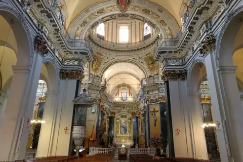 Wnętrze Soboru św. Mikołaja w Nicei z rzędami ławek i bogato zdobionym ołtarzem.