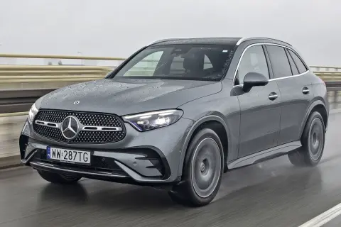 Szary Mercedes-Benz GLC jedzie po mokrej drodze.