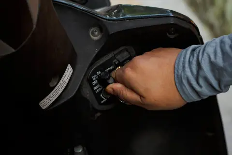 Mano girando la llave de encendido por magneto en una motocicleta.
