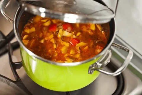 Gulasz w zielonym garnku na kuchence. Chcesz wiedzieć, jak zmniejszyć ostrość potrawy? Dodaj śmietanę lub jogurt.