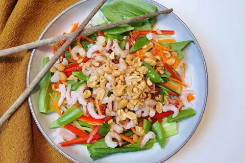 En fräsch asiatisk nudelsallad med räkor, grönsaker och jordnötter. Perfekt för en lätt lunch eller middag.