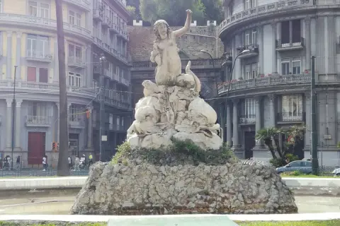 Fontana con statua di Partenope, figura mitologica legata a Ulisse, circondata da creature marine.