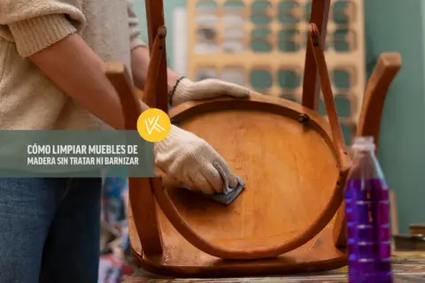 Persona con guantes limpia un mueble de madera, mostrando cómo limpiar madera sin dañar el barniz.