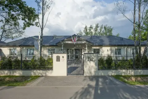 Elegancki lawendowy dom opieki seniora, z pięknym ogrodem i bramą.