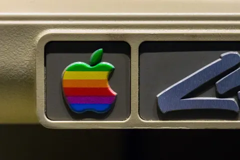 The iconic rainbow Apple logo, a testament to the original apple logo designer's vision, adorns an old computer.