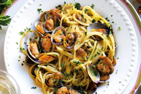Spaghetti alle vongole cremosi come al ristorante, un piatto invitante con pasta, vongole e prezzemolo fresco.