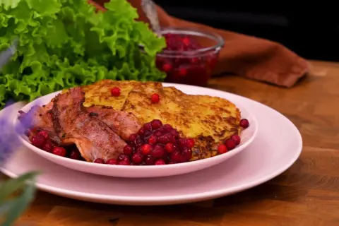 Rökt sidfläsk med stekt potatis och lingon, en härlig bit av traditionell svensk mat.