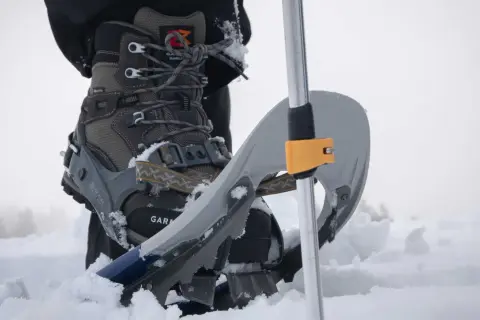 Scarponi e racchette da neve: scopri cosa sono le ciaspole per camminare sulla neve fresca, con un bastone da trekking.