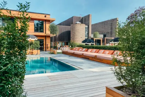 En avkopplande dag vid poolen på Ellery Beach. Solstolar i orange, parasoller och en klarblå pool.