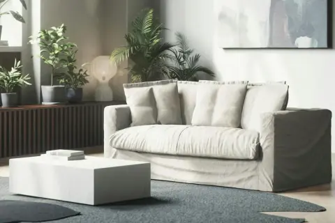 En ljus soffa med lösa dynor i ett modernt vardagsrum. Kanske dags att fixa nedsuttna soffdynor för att ge den nytt liv?