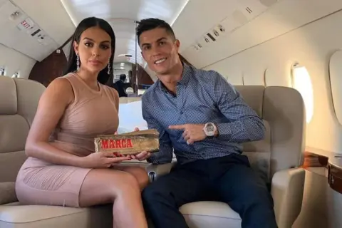 Georgina i Cristiano Ronaldo w prywatnym samolocie. Ona trzyma złoty przedmiot z napisem "MARCA".