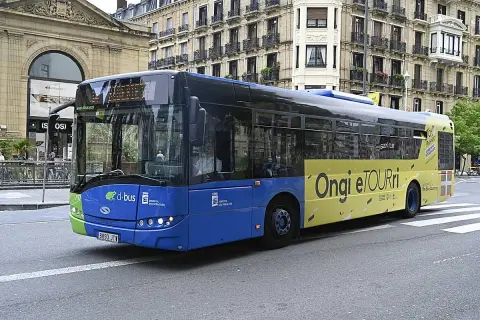 Autobús azul y amarillo de Dbus en Ondarroa, San Sebastián, con el lema "Ongi etorri".