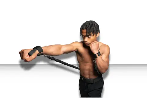 A boxer trains to punch faster using resistance bands attached to his wrists, building explosive power.