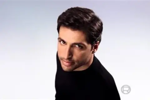Hombre con pelo seco y oscuro, con mirada intensa, viste de negro.