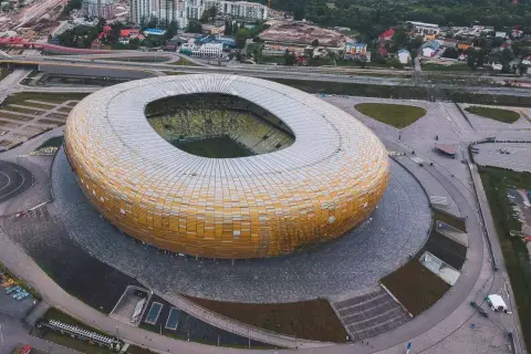 Widok z lotu ptaka na stadion w Gdańsku, z jego charakterystyczną, złotą fasadą. Idealne miejsce na zwiedzanie stadionu gdańsk i poczucie atmosfery wielkich wydarzeń sportowych.