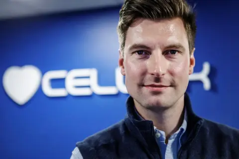 Erik Gatenholm, grundare av Cellink, ler mot kameran med en blå bakgrund med företagets logotyp.