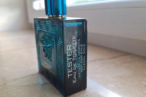 Niebieska butelka testera Versace Eros Eau de Toilette z greckim wzorem i Meduzą.