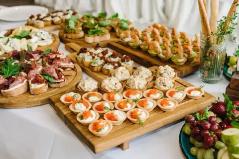 Vielfältige Snacks zum Aperitif: Bruschetta mit Salami, Käseplatte, Garnelen-Häppchen und süße Törtchen mit Kaviar.