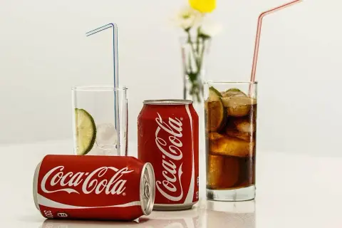 Puszki i szklanki z Coca-Colą, lodem i limonką. Zastanawiasz się, ile kalorii ma Coca-Cola?