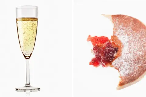 Glas Prosecco und ein angebissener Krapfen mit Marmelade. Über Prosecco Kalorien muss man sich hier wohl keine Gedanken machen.