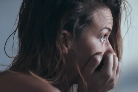 Kobieta w profilu, zamyślona, trzymająca dłoń przy ustach. Może szuka ulgi w **duloxetine**.