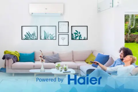 Coppia rilassata sul divano, godendosi la temperatura ideale in casa grazie a Haier.