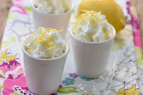 Délicieuse mousse ricotta citron, garnie de zestes frais et servie dans de petits ramequins blancs. Un dessert léger et rafraîchissant.