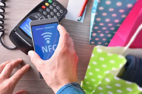 Zbliżasz telefon do terminala płatniczego, by zapłacić zbliżeniowo. To właśnie co to NFC – technologia, która ułatwia płatności mobilne.
