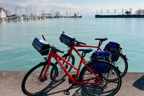Zwei rote Fahrräder stehen am Ufer des Bodensees in Friedrichshafen, bereit für eine Tour.