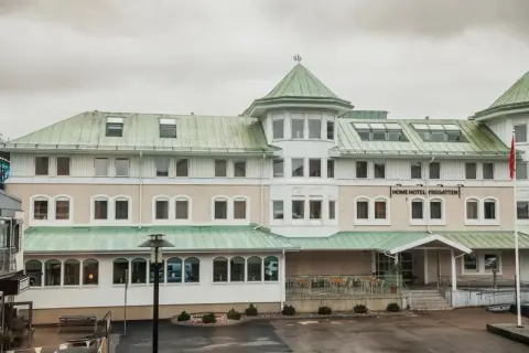 Home Hotel Fregatten i Varberg, med sitt gröna tak och ljusa fasad, välkomnar gäster.