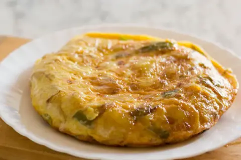 Złocista tortilla ziemniaczana z zielonymi papryczkami, idealna na śniadanie bez chleba.