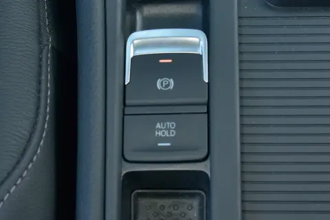 Przycisk auto hold w samochodzie, obok hamulca ręcznego.