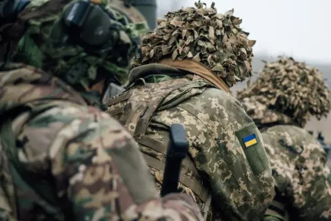 Żołnierze w kamuflażu, z ukraińską flagą na ramieniu, gotowi do akcji. Myślą o domu, ale nie o dezercji.