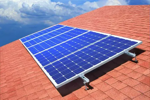 Paneles solares azules sobre un tejado rojo, capturando la energía del sol. ¿Quién inventó las placas solares?