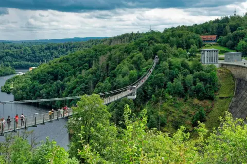 Hängebrücke über die Rappbodetalsperre, ein beliebtes Ausflugsziel im Harz. Menschen spazieren über die Brücke, umgeben von grünen Wäldern.