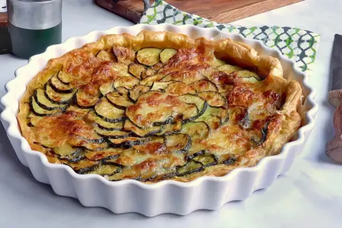 Tarte dorée aux courgettes et mozzarella, prête à être dégustée.