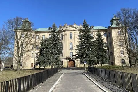 Pałac w Osiecznej, otoczony drzewami, zaprasza do odkrywania jego historii i uroków.