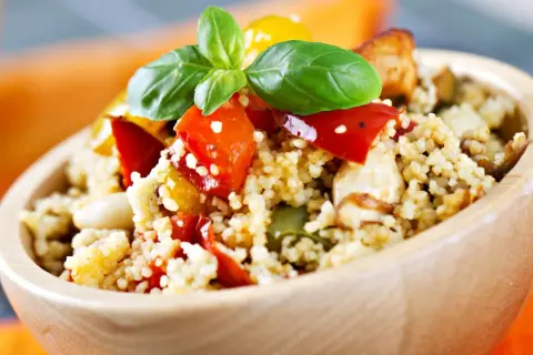 Ciotola di couscous con verdure miste e basilico, un piatto ideale per lo svezzamento a 6 mesi.