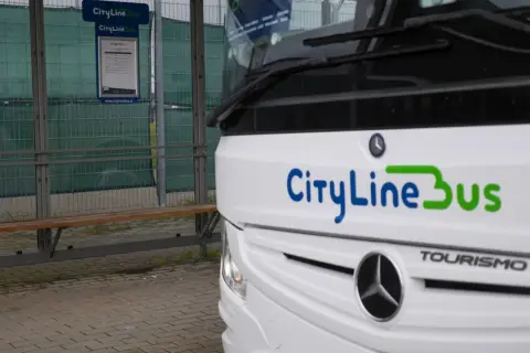 Autobus CityLineBus czeka na pasażerów na przystanku. Może to być podróż z Kielc na lotnisko w Katowicach.