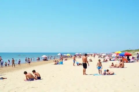 Tłum ludzi na plaży, idealne miejsce na wakacje. Gdzie najbliżej nad morze z Warszawy? Tutaj!